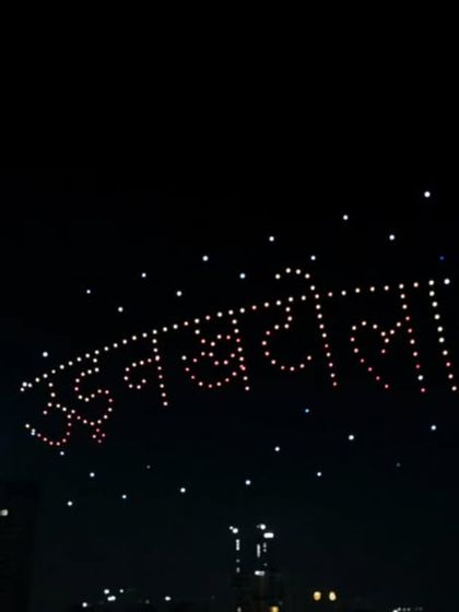 The words 'Udan Khatola' (flying machine) float above the city during the Piyush Mishra concert. This formation was a poetic nod to his famous song and the magic of flight.