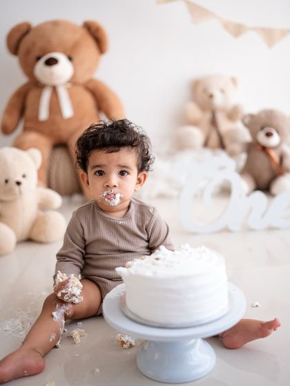 A teddy bear-themed cake smash in progress. These sessions are all about capturing your baby's genuine reactions.