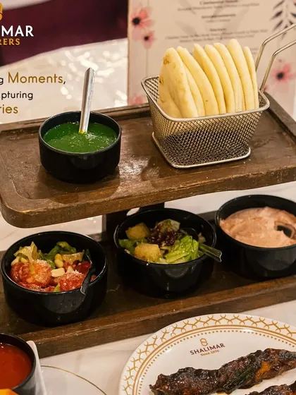 Savoring moments while capturing memories. Our vibrant Mezze Platter, with fresh pita, salads, and dips like hummus and mint chutney, offers a delightful taste of the Mediterranean.