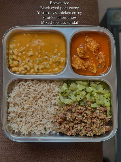 A hearty meal of brown rice, black-eyed pea curry, leftover chicken curry, sautéed chow chow, and mixed sprouts sundal.