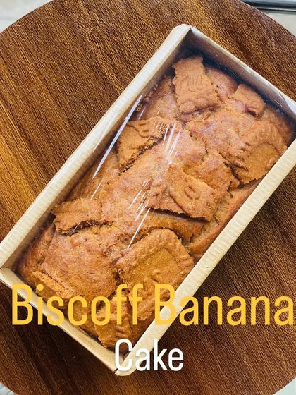 A single Biscoff banana tea cake, wrapped and ready to be delivered. This loaf cake is moist and flavorful, with the sweet spice of Biscoff in every bite.