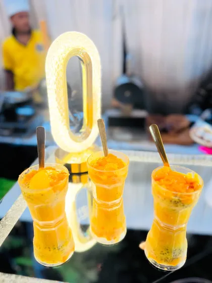 An artistic shot of the Mango Falooda glasses, illuminated to highlight their vibrant colors.
