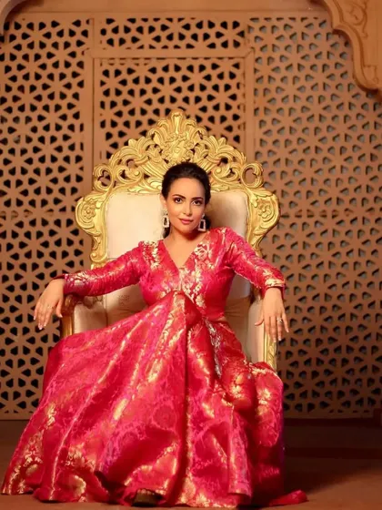 A regal, full length portrait. The actress looks like modern royalty seated on the throne, and her glowing makeup adds to the luxurious and festive feel of the image.