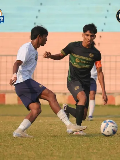 A player uses their body to hold off a defender while controlling the ball.