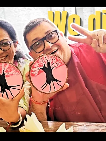 "We did it!". The proud smiles of two participants showing off their finished wood slice paintings. It's a wonderful feeling to create something beautiful together.