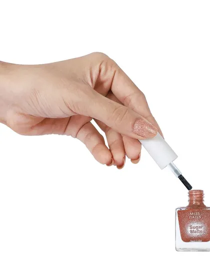 A hand holding the nail polish applicator over the open bottle, demonstrating how the product is used. This action shot is effective for secondary images on a product detail page.