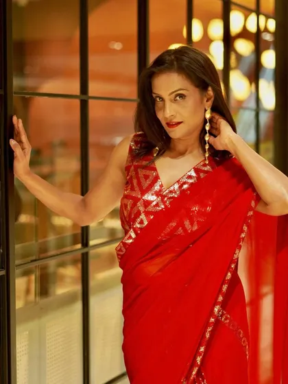 A close-up look at the sequin and thread work on the blouse and border of this red party wear saree. The geometric pattern is modern and very chic.