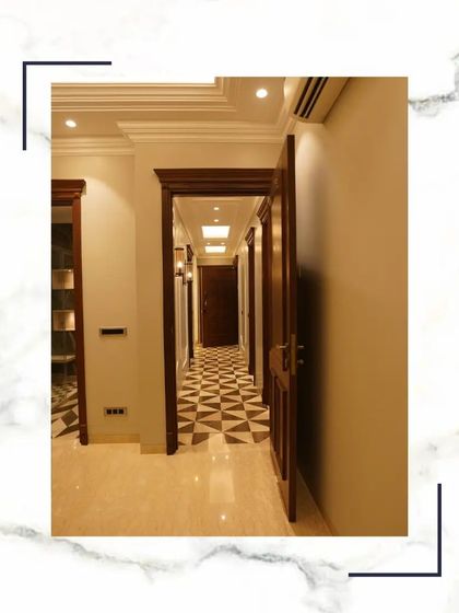 This hallway showcases the seamless integration of different elements. The checkerboard marble floor, the rich wooden door frames, and the clean, light walls all come together to create a harmonious and luxurious passage.