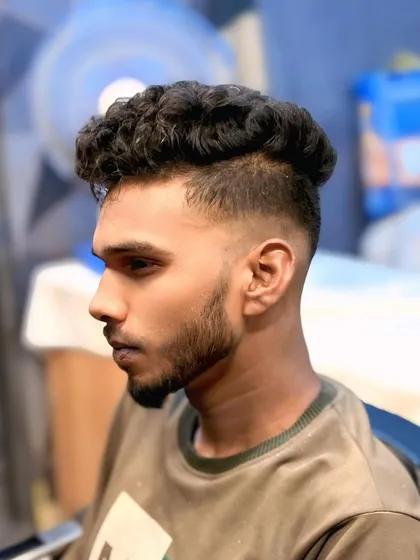 A zero fade with curly hair on top. I keep the sides extra short to create a clean look that makes the natural curls stand out.