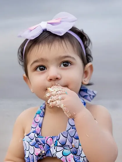 A close-up of the birthday girl enjoying a sweet taste of her cake, with the ocean waves in the background. We love these candid, detail-oriented shots.