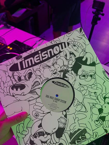 Holding a fresh vinyl dubplate. There's nothing like having your own custom tracks pressed to wax, ready to be played in a live set.