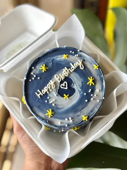 A starry night bento cake with a beautiful blue and white swirl, yellow stars, and a sweet birthday message.