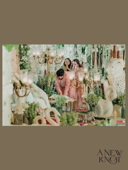 A moment of prayer and blessing at the serene 60th birthday Satsang, surrounded by beautiful white floral decor and elegant candelabras.