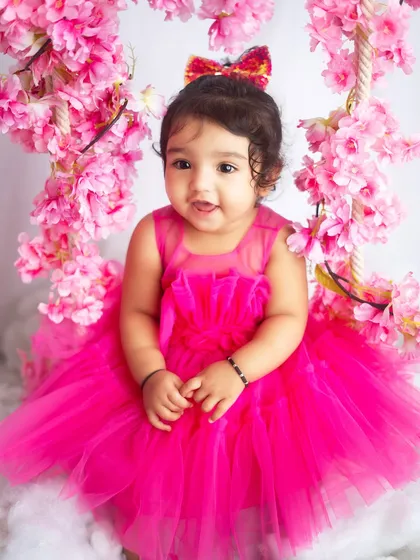 A pretty in pink portrait. This little girl looks like a doll, surrounded by cherry blossoms for her milestone session.