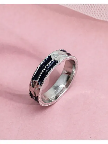 A stylish silver band ring with black enamel and star motifs. This piece is an example of crafted elegance, where modern design meets a desire for unique style.