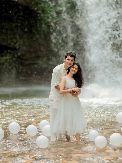 A happy and relaxed hug in front of the waterfall. This shot captures their joy and comfort with each other in a stunning natural setting.