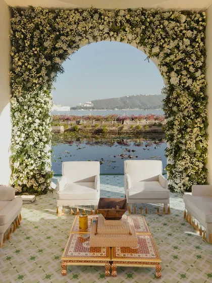 The view from within the mandap, looking out over the serene lake. We design our ceremony spaces to maximize the beauty of the destination, creating a backdrop that is both natural and breathtaking.