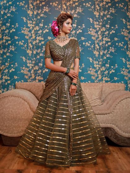 This olive green sequin lehenga-saree is a unique choice for a reception. I've paired it with a polki choker and green bangles to create a cohesive and stylish ensemble.