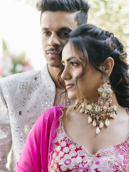 This close-up shows how the textured, braided hairstyle perfectly frames the bride's face and statement earrings.