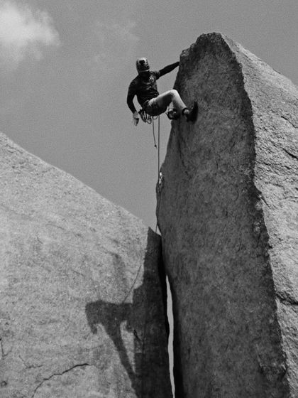 A dramatic black and white shot of Akash rappelling between two pillars. This photo captures the adventurous spirit of our community.