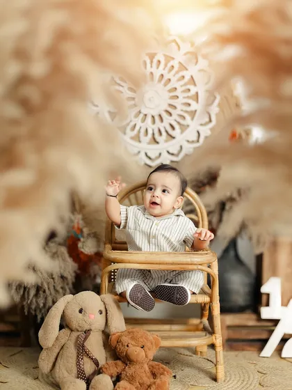 A cute wave from the star of the show. Sitter sessions are perfect for capturing these new skills and budding personalities.