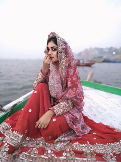 Wrapped in red, embraced by the Ganges. A portrait that speaks of finding a spiritual home in Varanasi, with the city's misty ghats in the background.