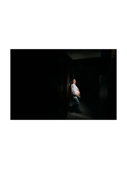 Another perspective of the dramatic, low-key lighting setup. This image captures the quiet strength and beauty of pregnancy in a minimalist and artistic way.