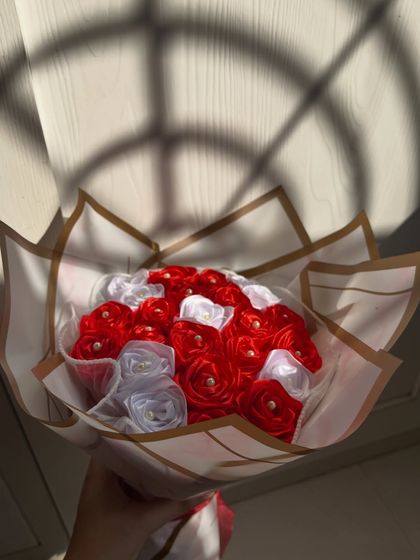 A full view of the classic red and white satin rose bouquet. The elegant wrapping and timeless color combination make it a sophisticated and romantic gift.