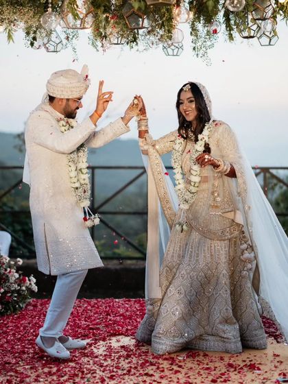A fun, celebratory dance move from the couple right after their varmala exchange, showing their joyful personalities.