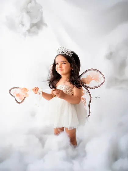 Holding her magic wand, this little fairy is ready to cast a spell of cuteness.