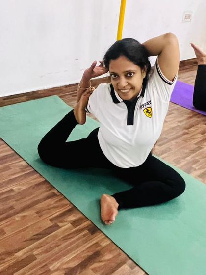 A smiling student in Eka Pada Rajakapotasana, the one-legged king pigeon pose. This is a beautiful heart-opening pose that also deeply stretches the hips.