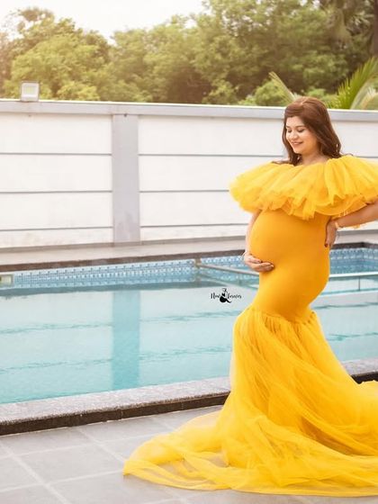 The vibrant yellow gown looks stunning against the cool blue of the swimming pool. This shot shows how we can use different outdoor locations for a glamorous feel.