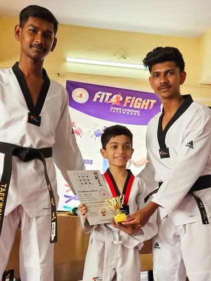 A young champion receives his trophy and certificate from our senior instructors. We believe in celebrating every achievement.