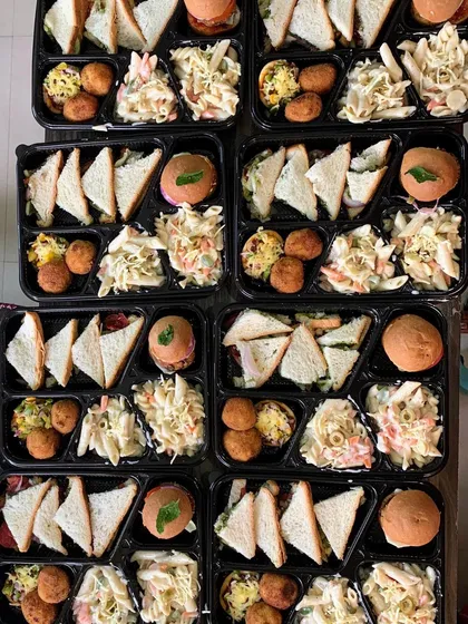 An overhead shot of multiple meal boxes prepared for a movie night get-together.