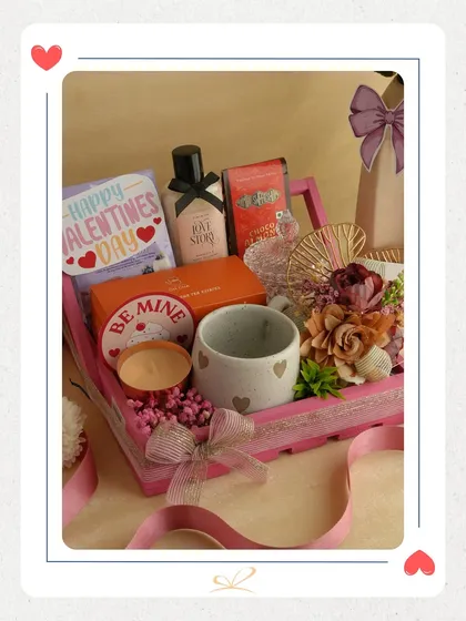 Another look at the 'Be Mine Box', showcasing the beautiful arrangement of a mug, candle, and other self-care items in a vibrant pink tray. It's a complete gift set for a pampering session.