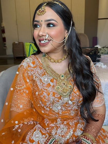 Another angle of the bride's half-up wavy hairstyle, showing how it complements her ornate nath and maang tikka.