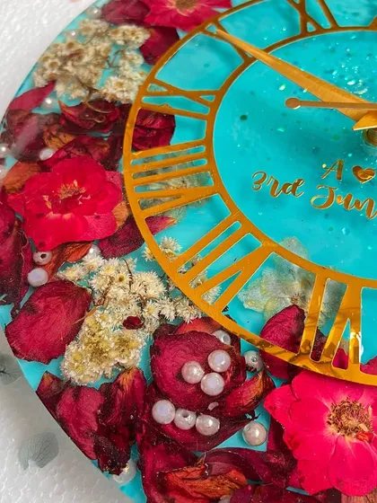 A close-up view of the turquoise clock, highlighting the rich colors of the preserved flowers and the glossy resin finish.