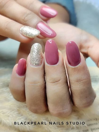 An elegant combination of pinky-nude polish with a champagne glitter accent nail. This is a sophisticated way to incorporate sparkle into a manicure without it being overwhelming.