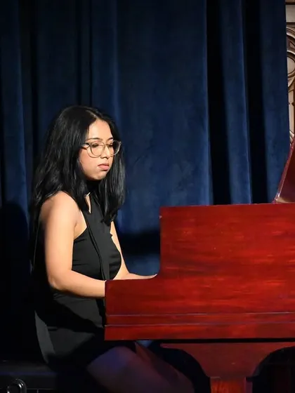 A student pianist delivering a powerful and emotional performance. Our piano curriculum is designed to develop both technical skill and artistic expression.