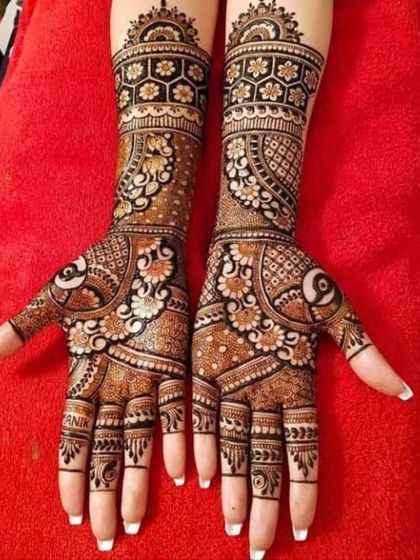 Full coverage bridal mehndi with a beautiful blend of floral and geometric patterns. The name of the groom, "ANIK," is subtly hidden within the design on the fingers.