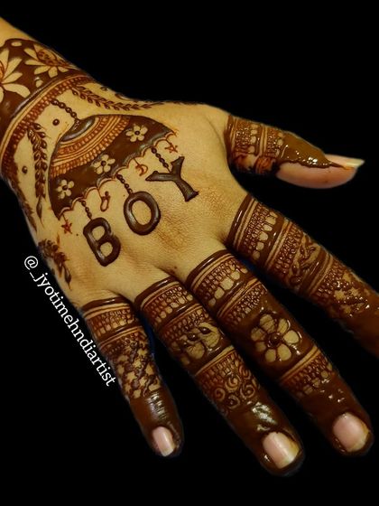 A simple yet charming back-of-hand design for a baby gender reveal, featuring an umbrella and the word "BOY".