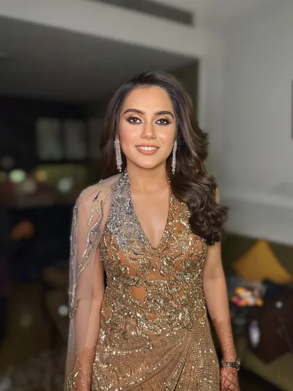 A stunning look for a cocktail or reception night. The hair is styled in classic Hollywood waves, which add a touch of old-school glamour to her modern, embellished gown.