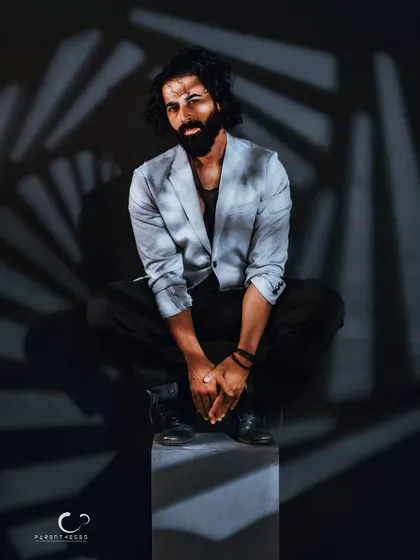 A slight shift in posture and gaze, but the intensity remains. This male portrait uses shadow patterns to create a visually complex and engaging character study.