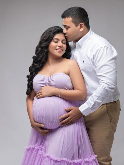 A sweet embrace in the studio. The soft lavender of her gown and his classic white shirt create a light and romantic color palette.