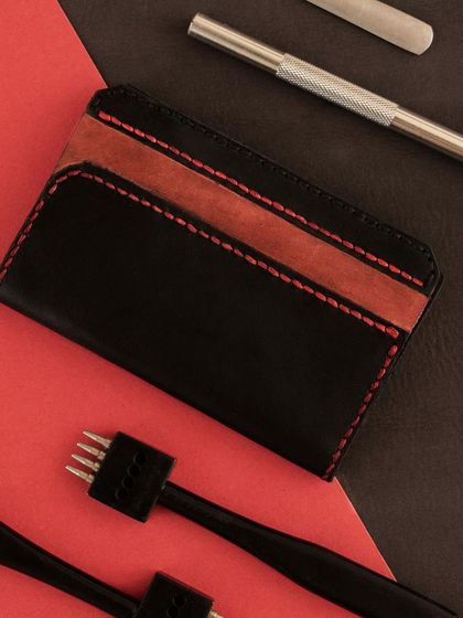 A duplicate of the leatherworking tools and finished cardholder, emphasizing the craft and precision involved in the process.