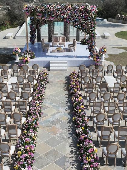 An aerial view of the wedding ceremony setup, showing the perfect symmetry of the seating arrangement and the floral aisle leading to the magnificent mandap. Every element is meticulously planned for a flawless guest experience and stunning visuals.