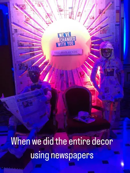 A wider view of our newspaper installation for 'The Hindu' event. The setup included two life-sized figures and a large, sun-like backdrop, all crafted from recycled newspapers to fit the theme.