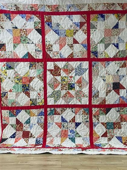 A scrappy star quilt with a red sashing that makes the individual star blocks pop.