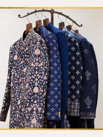 A rack displaying a collection of our intricately embroidered sherwanis in shades of blue. This image represents the magic of vibrant hues and luxurious fabrics that define our brand.