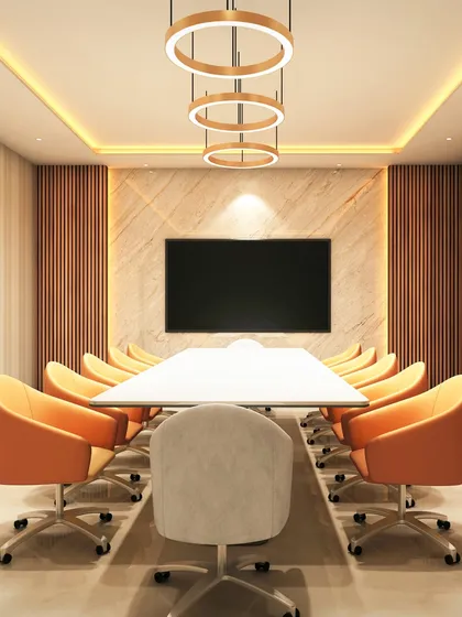 This conference room at The Shri Ram Universal School is designed for strategic collaboration. The combination of a marble accent wall, wood panelling, and bold orange seating creates a space that is both professional and energizing, fostering productivity and innovation.